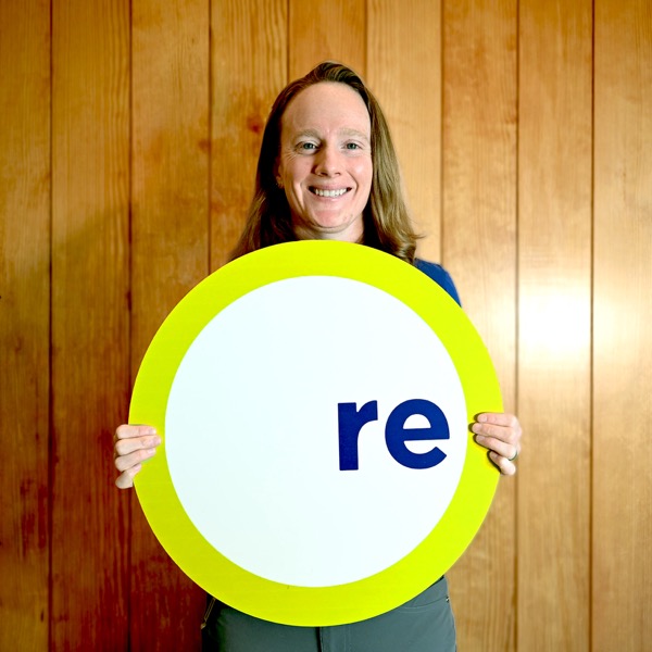 Bri, team member, holding a REdesign.build sign