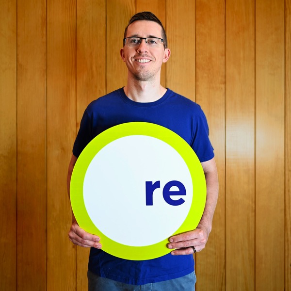Nicholas, team member, holding a REdesign.build sign